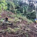 Longsor Kali >> Petugas melakukan pembersihan jalan yang tertimbun longsor.