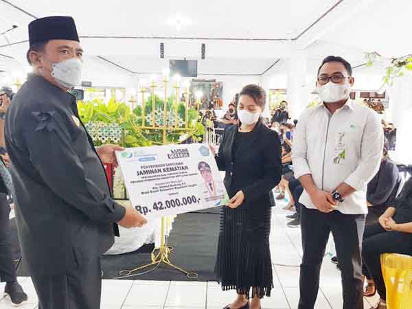 Bupati Sangihe (kiri) menyerahkan santunan kepada ahli waris Wabup Helmud Hontong, Senin (14/6).