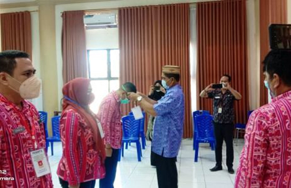 >> Drs Kahrudin MAP, memasang tanda pengenal kepada peserta Ujian Dinas dan Penyesuaian ijazah.