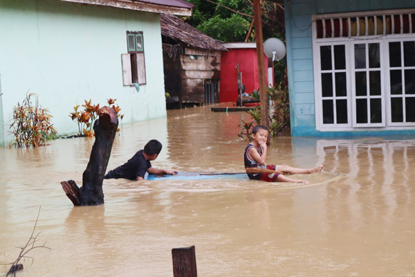 Banjir yang menggenangi rumah penduduk di wilayah Kabupaten Bolaang Mongondow Selatan. Ketinggian air nampak mencapai pinggang orang dewasa.